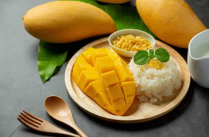 Rappresentazione del mango affettato in tavola, servito con riso