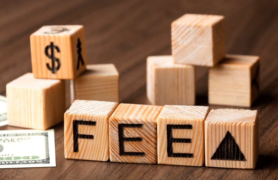 wooden blocks with the word "fee" indicating Blockchain transaction fees
